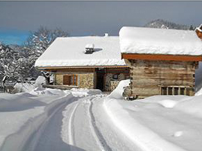Sonnige Almhütte im Schnee in den franzoesischen Bergen